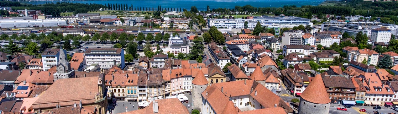 Swiss-Fly - Boris Bron - Photographie aérienne de la ville d'Yverdon-les-Bains prise par un drone où l'on voit le château, la place Pestalozzi et le lac 